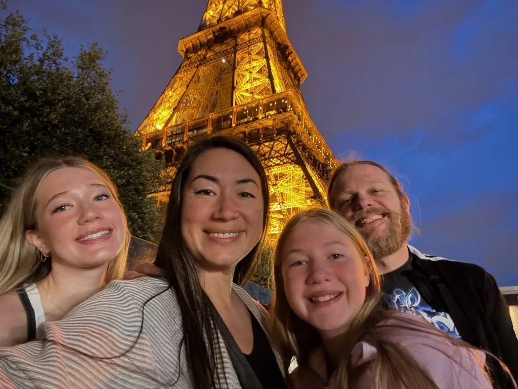 Smiling family photo under the Eiffel Tower